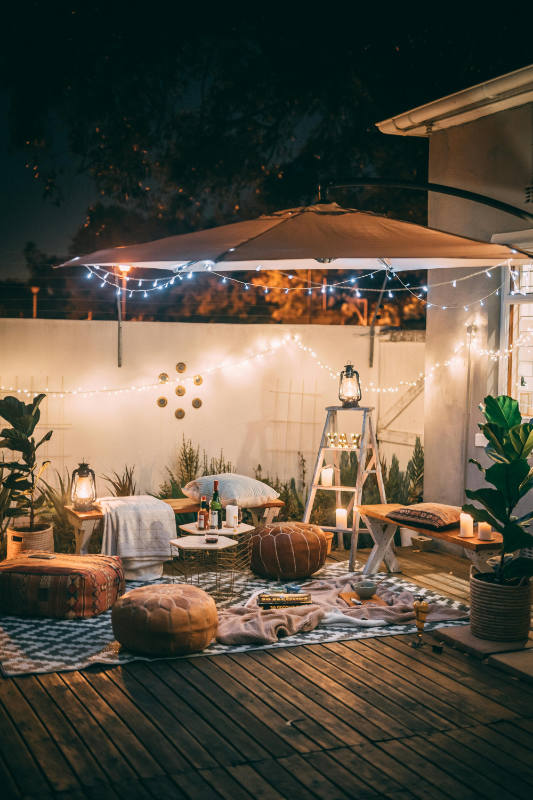 Terrasse extérieure avec guirlande, parasol et mobilier cozy